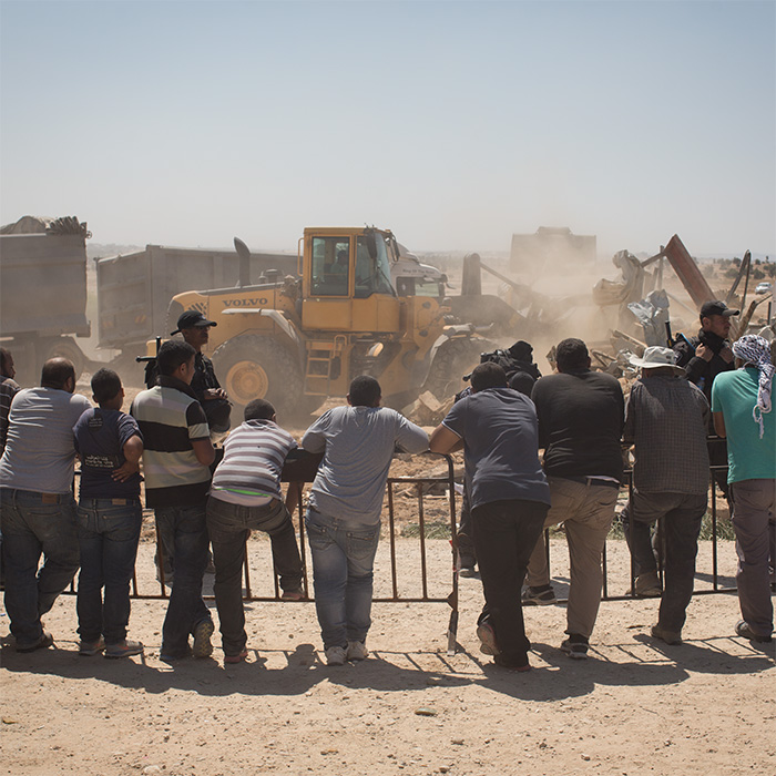 Residents of a Bedouin village watching their homes being demolished by the Israeli government